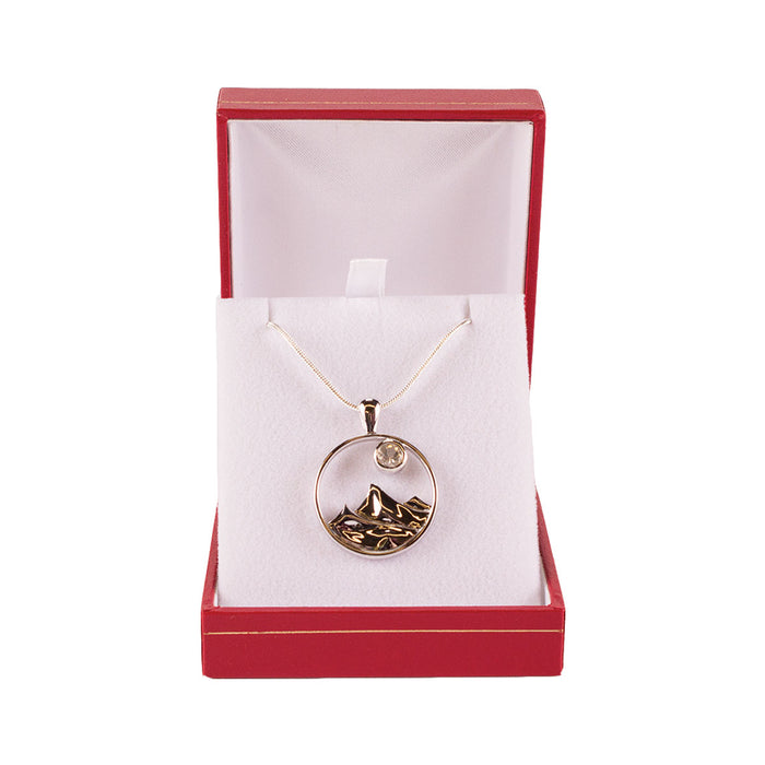 Sterling silver circle pendant with mountain range design and clear 5mm sunstone.