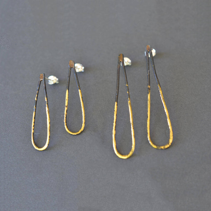 Narrow Drop Earrings in blackened steel with 23k gold leaf, slim teardrop design, and sterling silver posts—minimalist jewelry with a little golden drama.