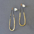 Narrow Drop Earrings shown in the short 1.5-inch length, featuring heat-patinated steel and 23k gold leaf for a sleek, stylish drop with serious sparkle.
