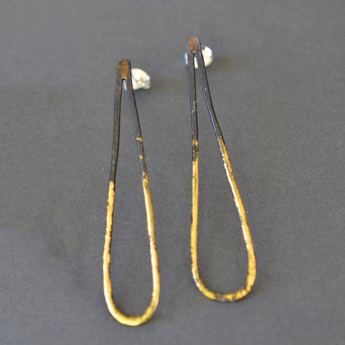 Narrow Drop Earrings shown in the long 2-inch length, crafted from blackened steel and 23k gold leaf—tall, elegant teardrops ready to make an entrance.