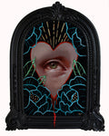 Artistic depiction of a heart with an eye and floral elements in a decorative frame.