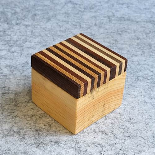 Twist Top Wooden Box with Stripes showing the striped lid and compact round interior